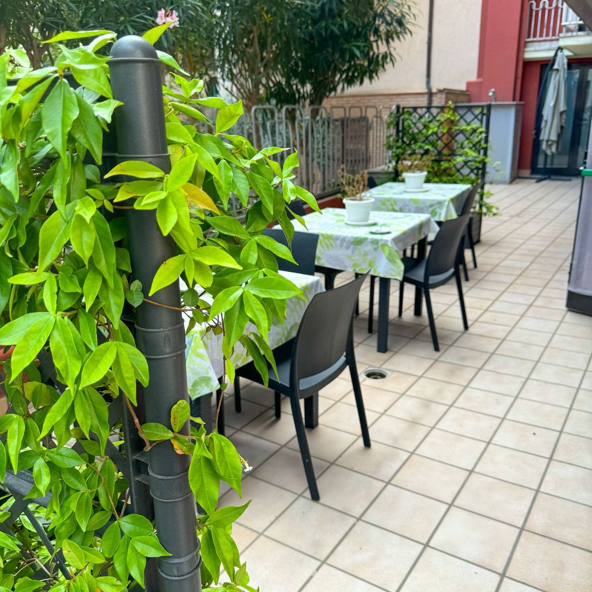 Terrazza esterna con tavoli tra il verde